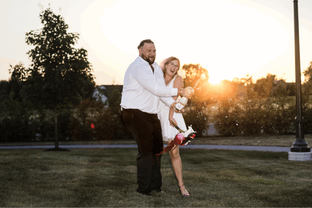 Bride and Groom Pop bottle of champagne at the willows at ashcombe wedding venue